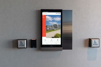 A wall-mounted device displays a weather forecast on its screen.